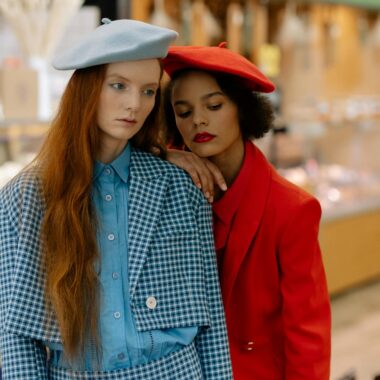 Two fashionable women wearing berets and chic outfits in a supermarket setting.
